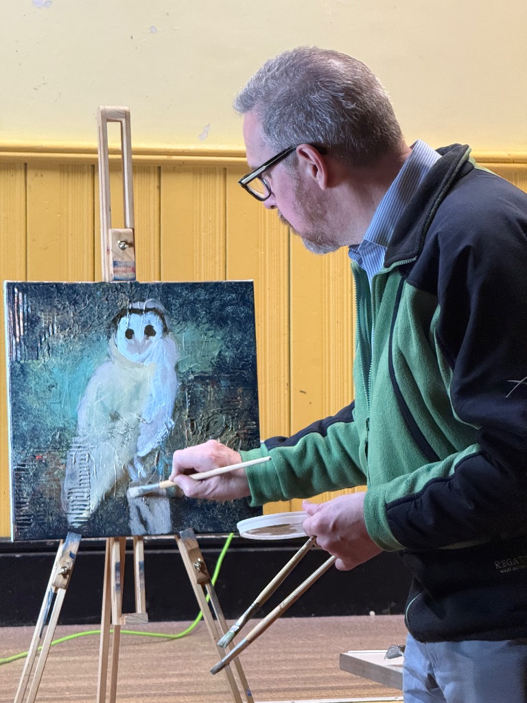 Surrey art group demonstration showing Ian painting realistic owl over textured background