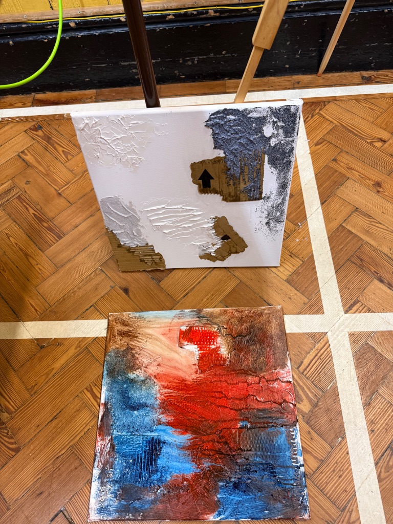 Abstract acrylic texture samples on floor showing various texture mediums and color applications